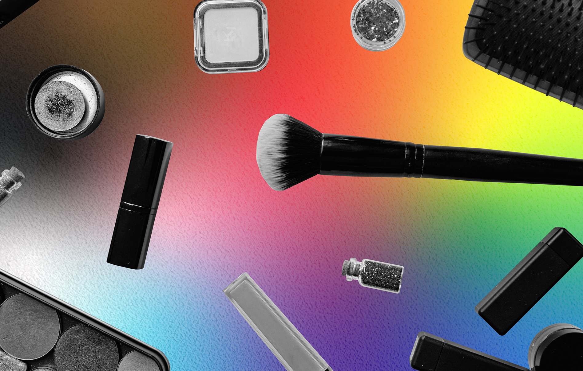 An assortment of beauty tools scattered across a pride-based gradient background