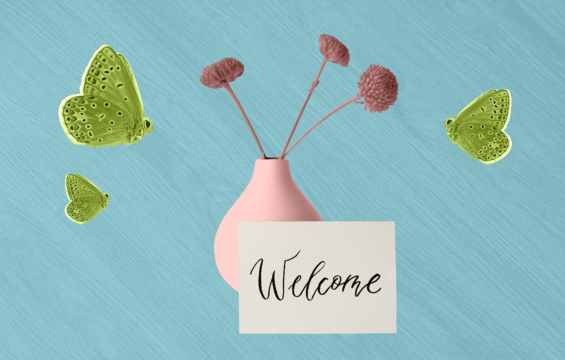 Image of a card with "welcome" written on it propped up against a vase with flowers surrounded by butterflies