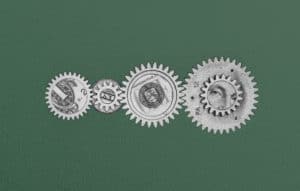 Four gears with dollar bill imagery overlaid on top of each