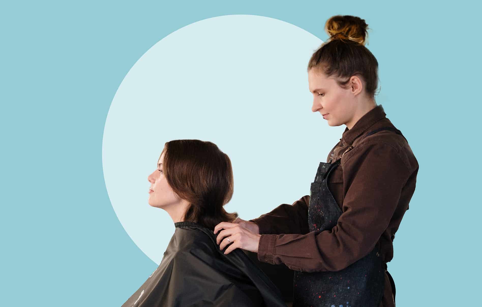 A stylist preparing a client for a cut